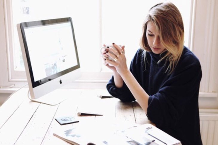 mujer con computadora leyendo 