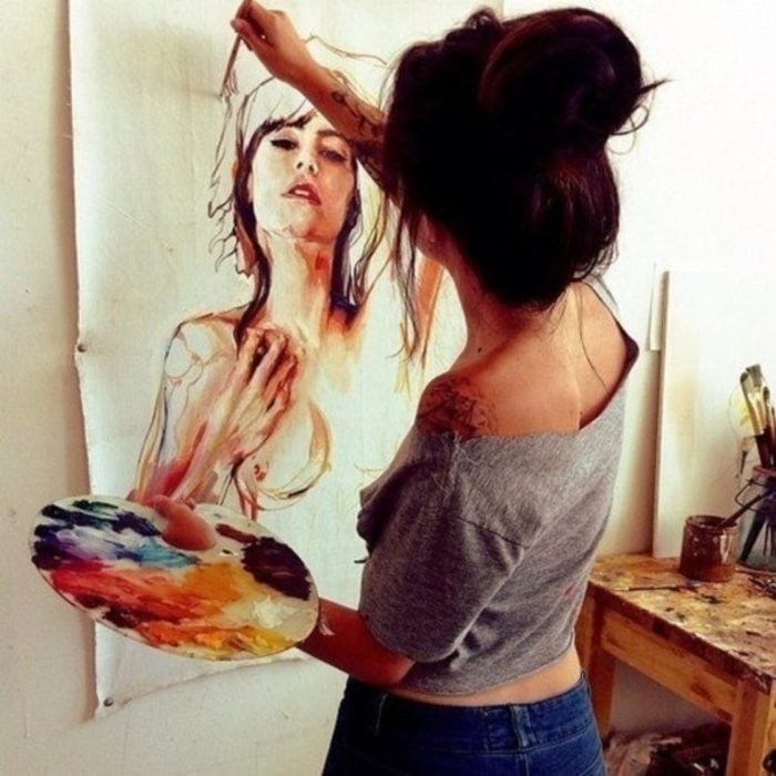 mujer con cabello agarrado y pintando 