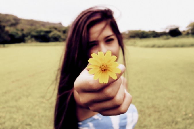 mujer con flor en la mano 