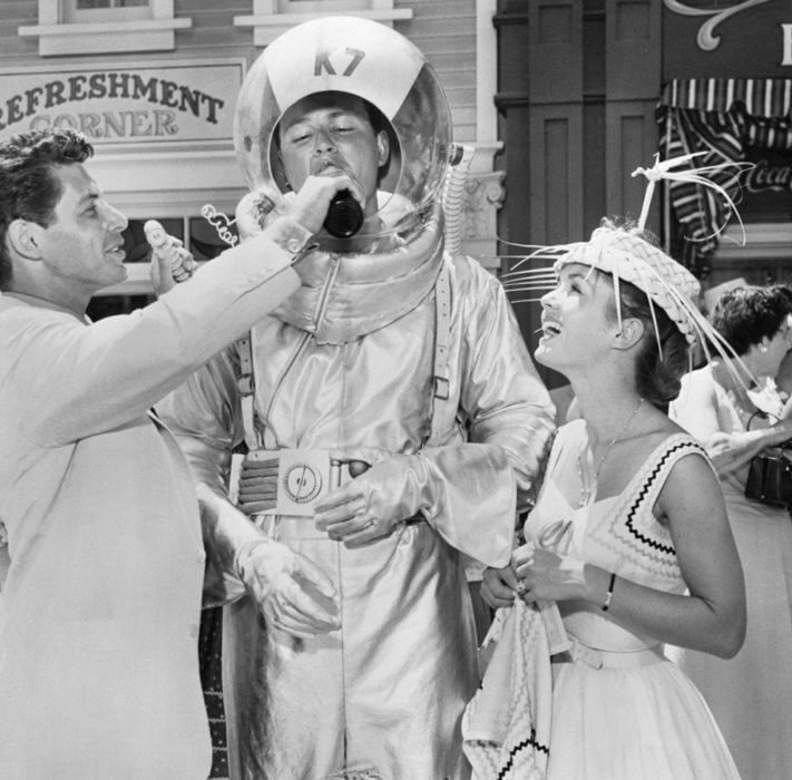 Actor dandole una bebida a un austronauta en disneyland en 1955