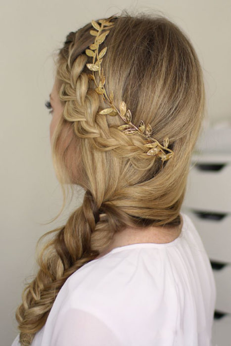 Chica con una trenza de lado y un adorno de hojas en el cabello 