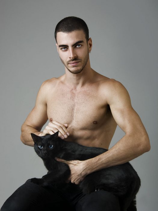 Modelo posando con un gato negro. 