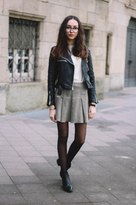 Chica usando una falda gris y una chaqueta de piel 