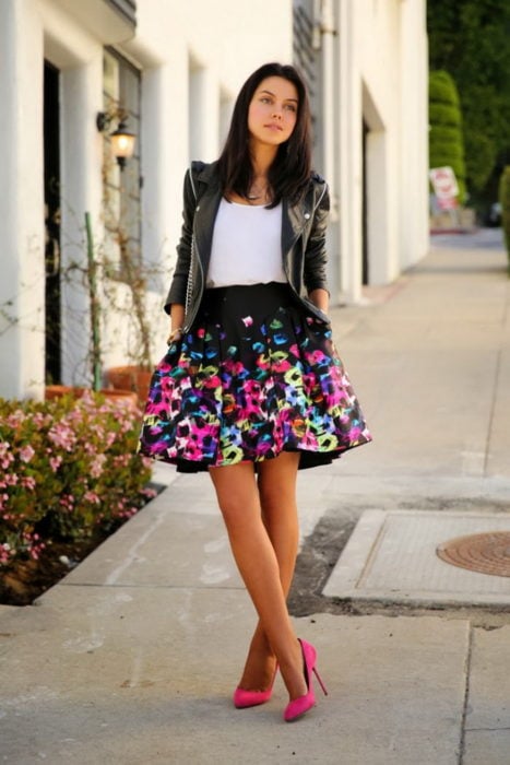 Chica usando una falda con estampados florales y chaqueta de cuero 