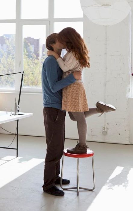 Mujer pequeñas besando a su novio. 