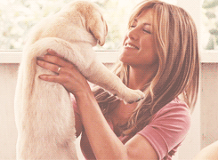 Jennifer Aniston mimando un perrito. 