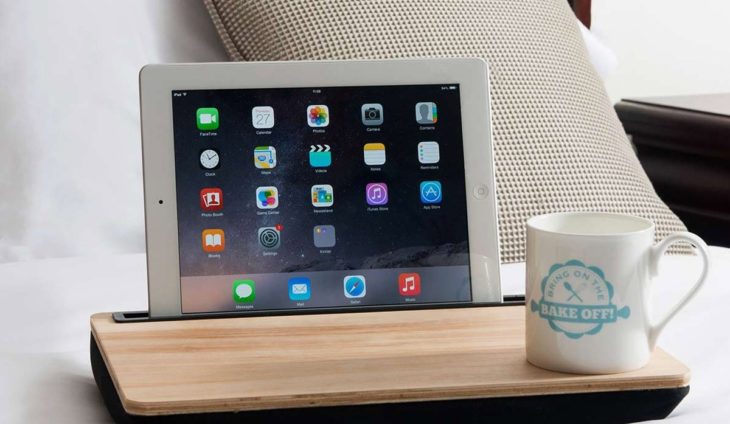 mujer con tabla en la cama y tablet 