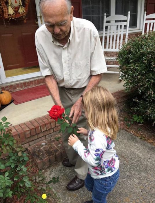 El señor Dan regalándole una rosa a la pequeña. 