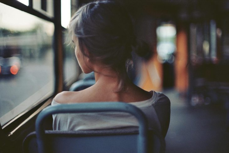 Muchacha mirando por la ventana de un autobús. 