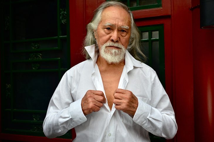 Wang Deshun desabotonándose la camisa. 