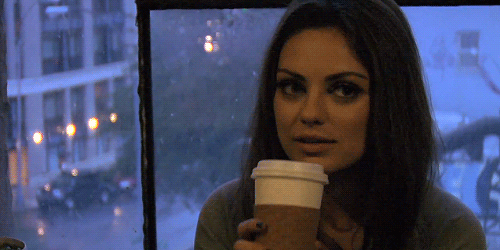 Mila Kunis bebiendo café. 