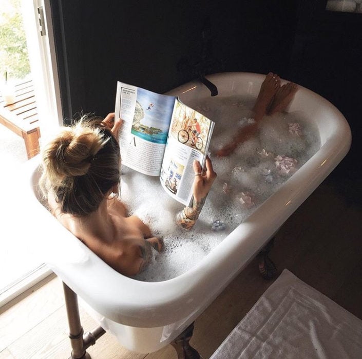 Chica relajada tomando un baño en una tina