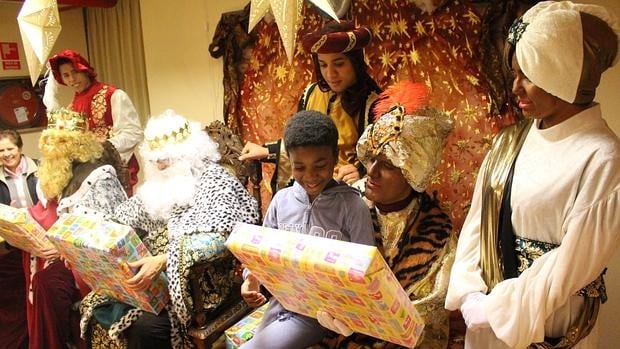 Reyes magos entregando regalos a los niños