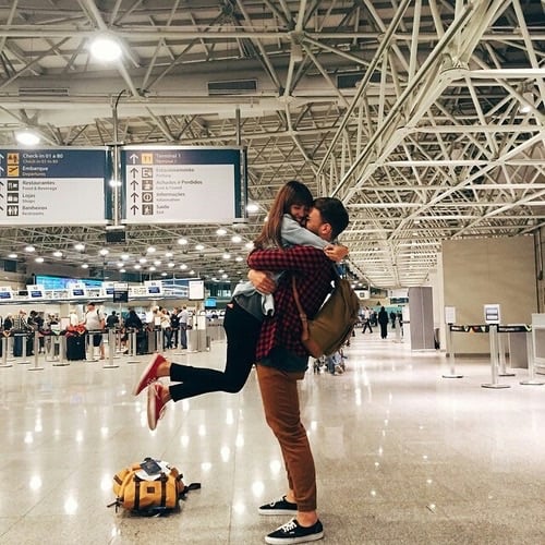 chica recibiendo a novio en aeropuerto