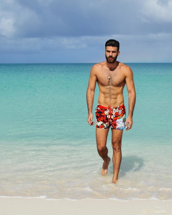 hombre sin playera en la playa 