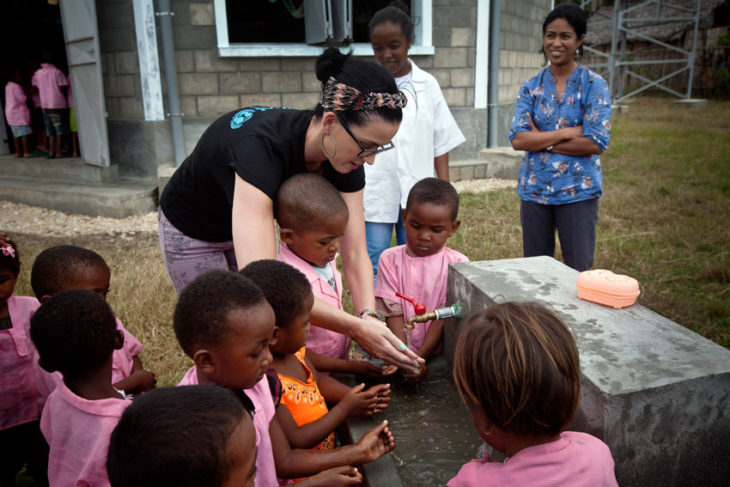 chica generosa ayudando niños