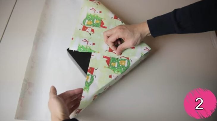 manos de hombre doblando papel de regalo 