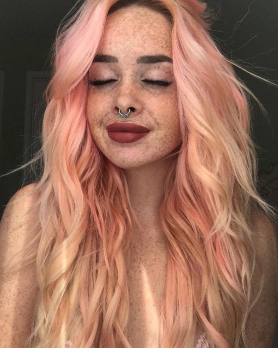 Chica de cabello rosa con pecas 