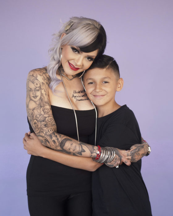 Madre con tatuajes abrazando a su hijo 