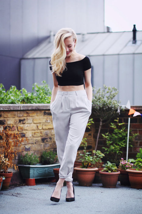 mujer con top negro y pantalon blanco 