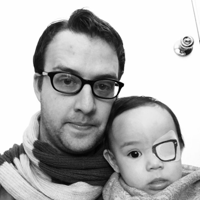 hombre con lentes al lado de bebe con un parche dibujado de lente