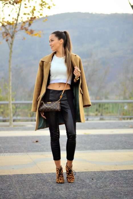 mujer con crop top blanco y abrigo 