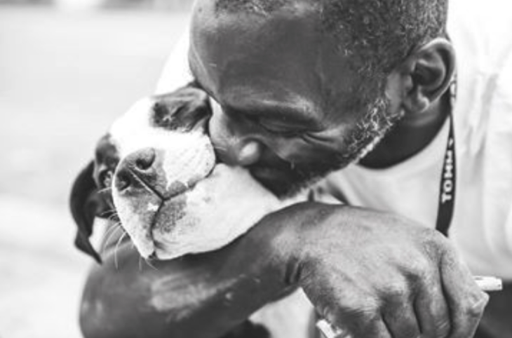 Hombre besando a su perro 