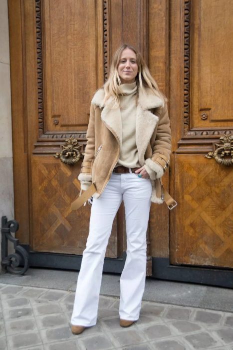 mujer con chamarra de borrego y pantalones blancos