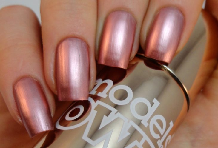 manos con uñas de color rosa metalico 