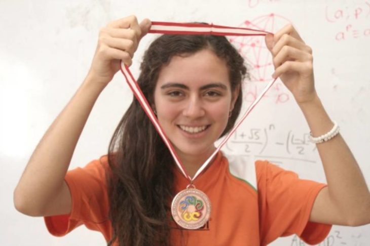 mujer con el cabello largo cargando una medalla 