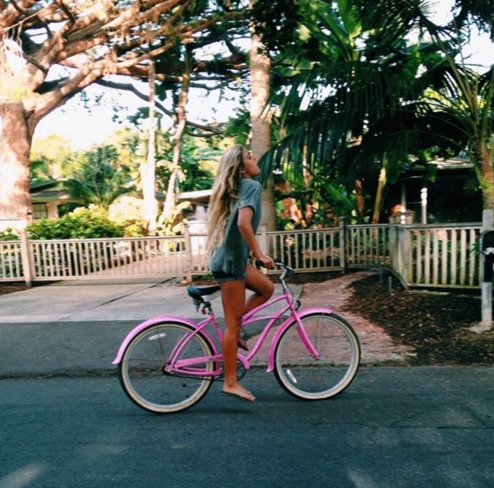 mujer en bicicleta rosa 