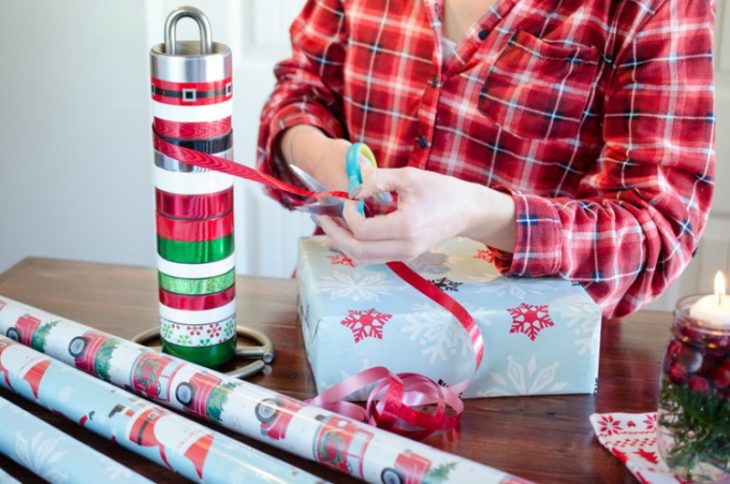 mujer envolviendo regalos con papel y moños