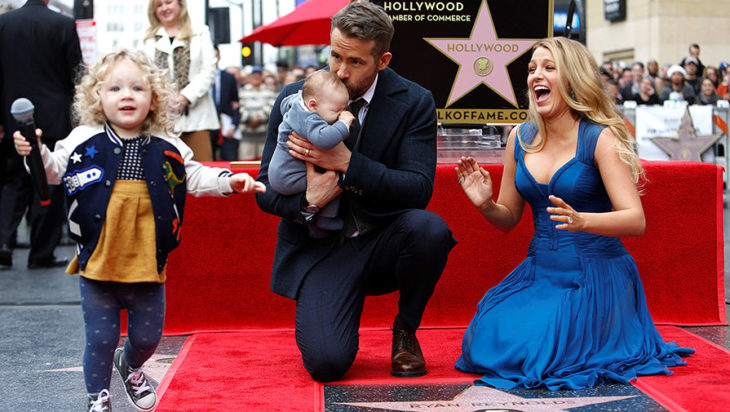 hombre cargando bebe, niña jugando y mujer rubia 