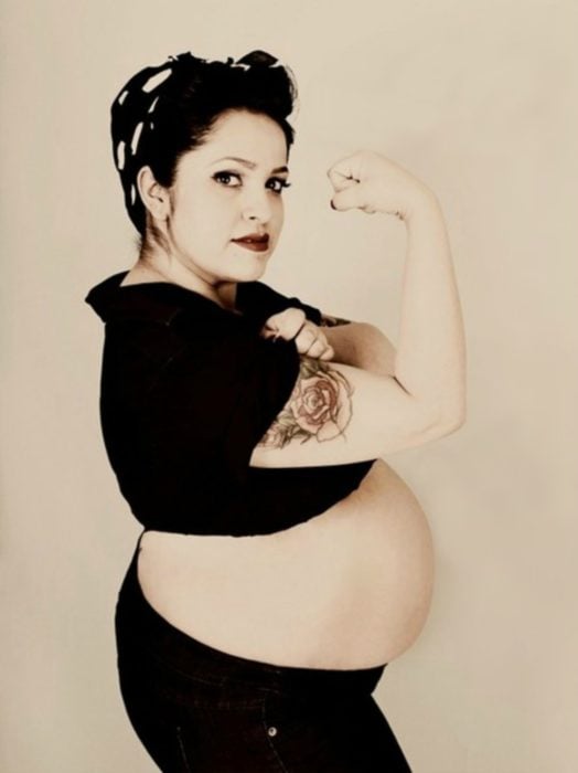 mujer embarazada con brazo de poder femenino