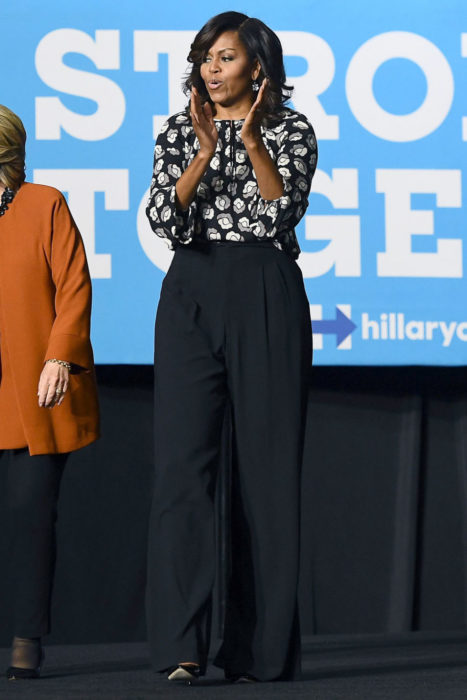 Michelle obama usando un traje en color negro con una blusa de flores 