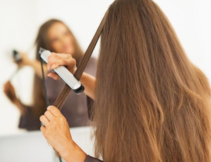 chica planchando su cabello