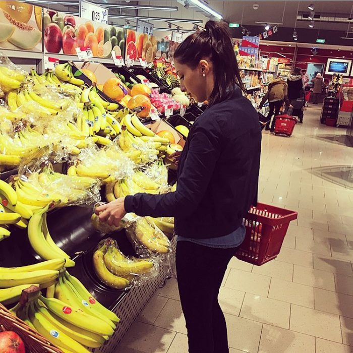 mujer en super mercado comprando platanos