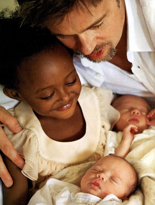 niña cargando a dos recien nacidos y papá