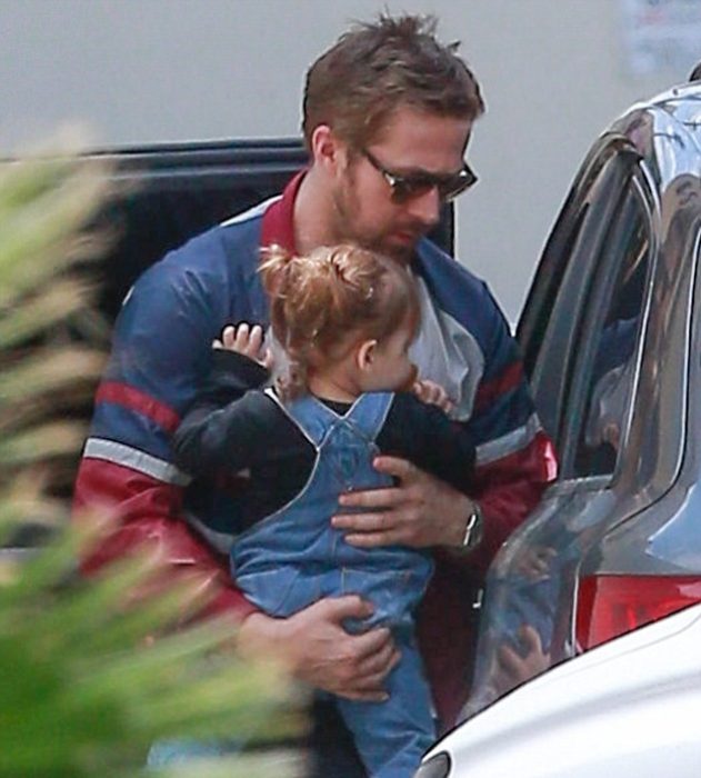 hombre cargando a niña en coche