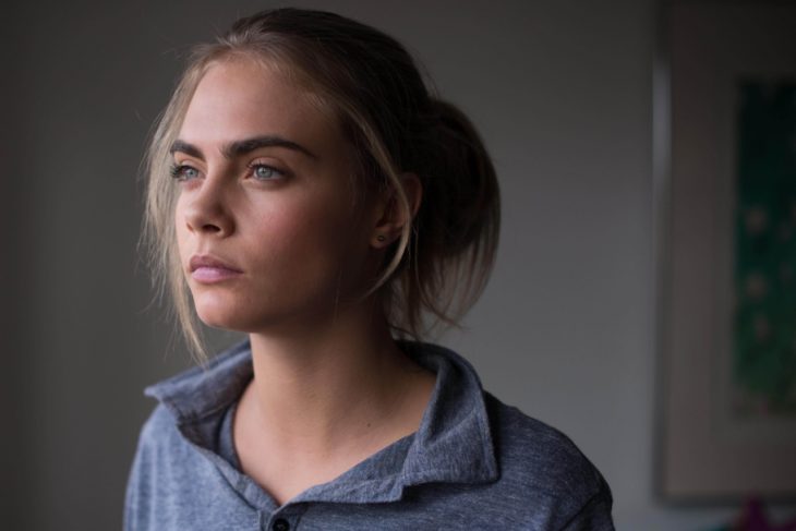 mujer rubia de ojos azules mirando por la ventana