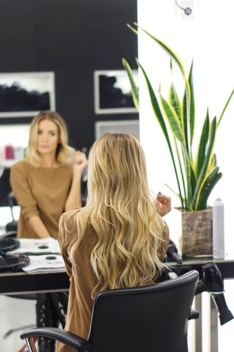 mujer rubia sentada frente el espejo