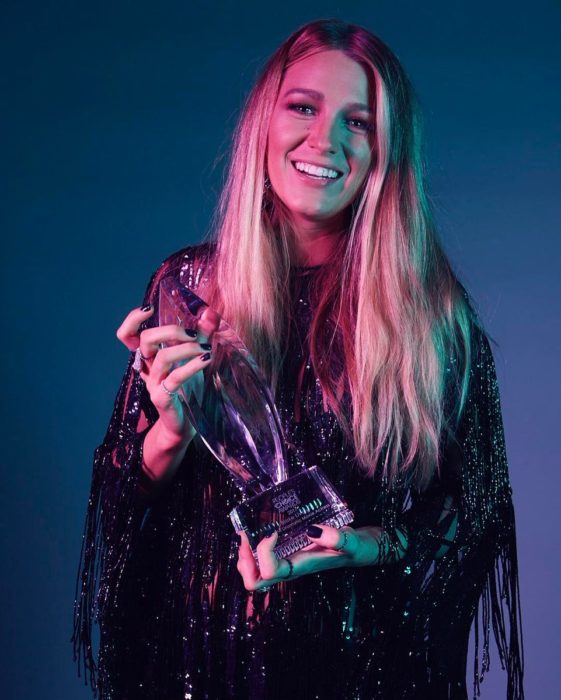 mujer rubia con premio y luces rosas