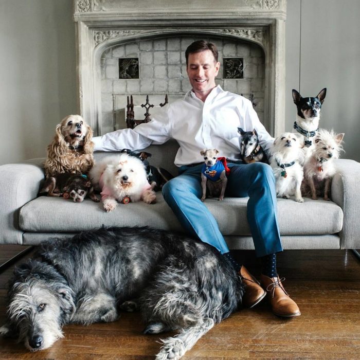 HOmbre sentado junto a sus perros 