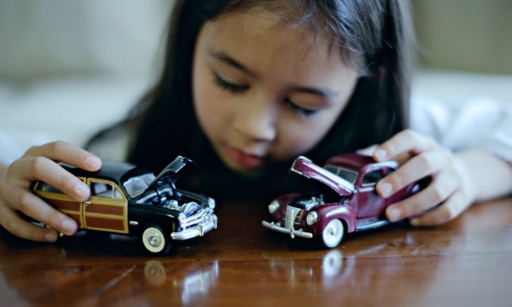 niña jugando con carros