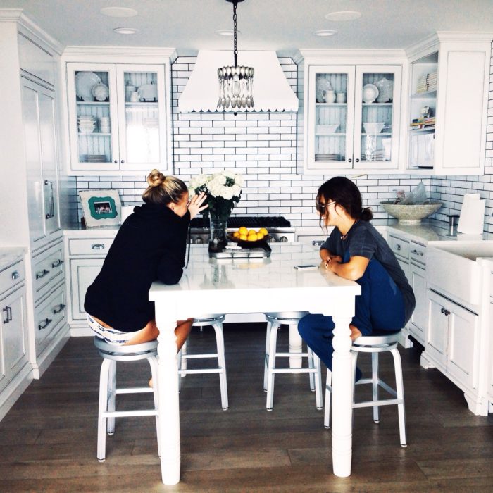 Chicas sentadas en la cocina hablando