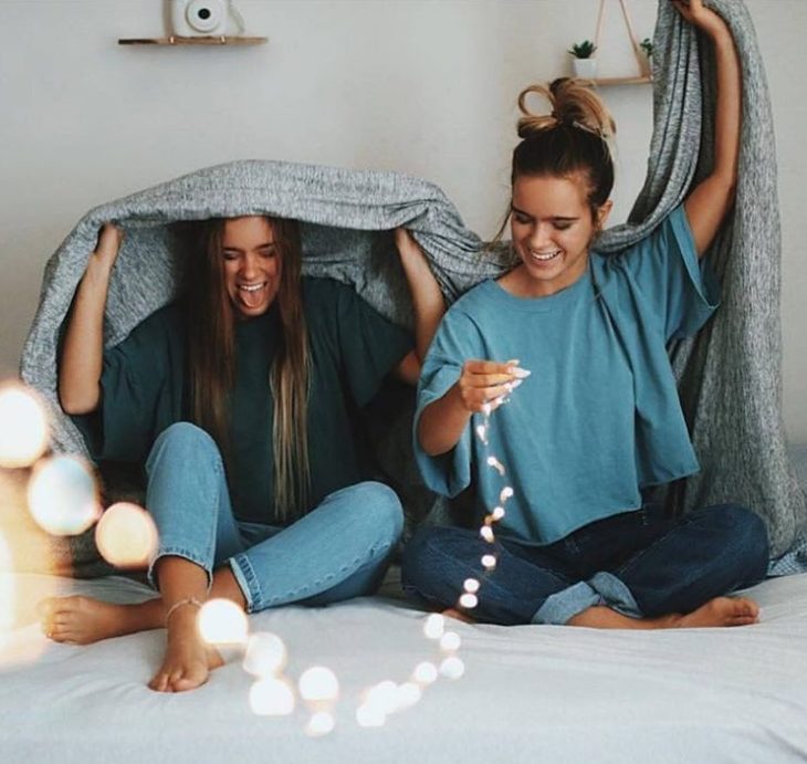 Chicas sentadas en una cama conversando