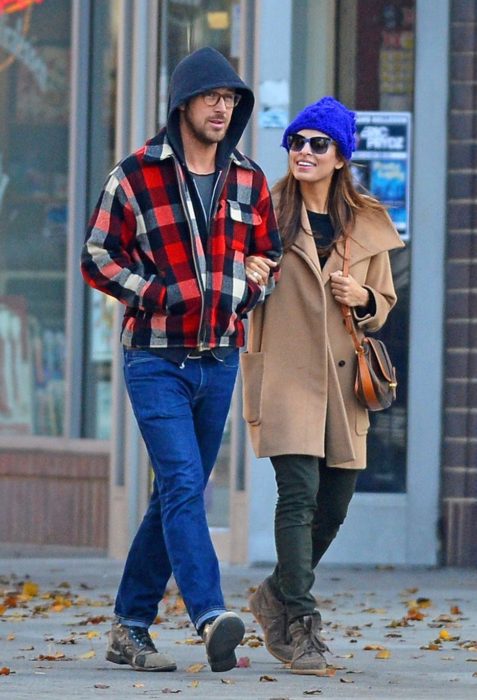 hombre con chamarra al lado de mujer con gorro y lentes 