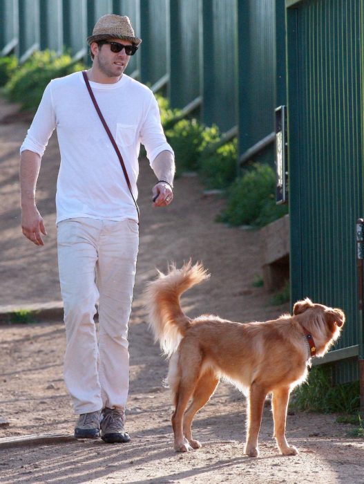 hombre con playera blanca y perro 