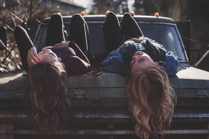 amigas platicando acostadas sobre una camioneta