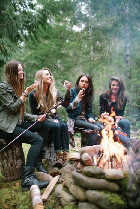 chicas asando bombones en una fogata